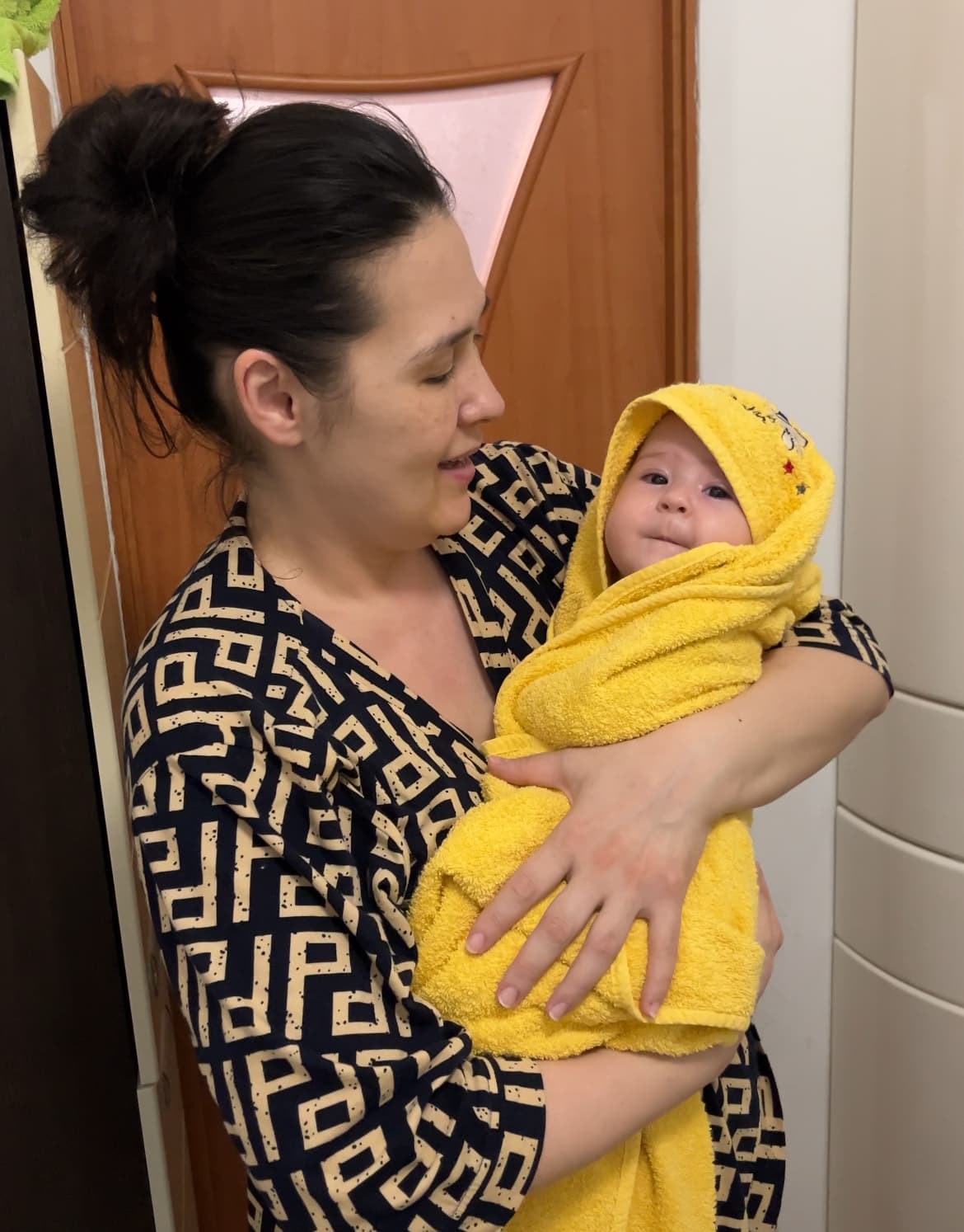 Счастливая мама с малышом после занятия плаванием